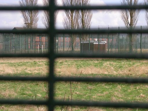 A distant view of the accomodation block through the fencing.