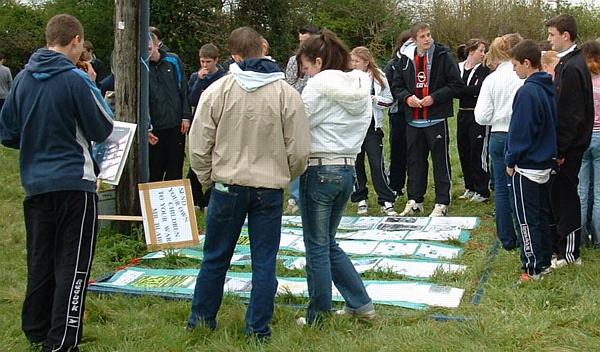 Local teenagers reading peace camp information board